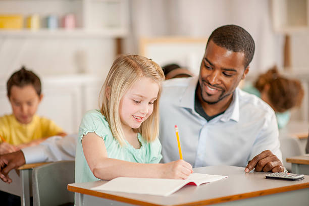 istock Teacher Helping Little Girl 487411300