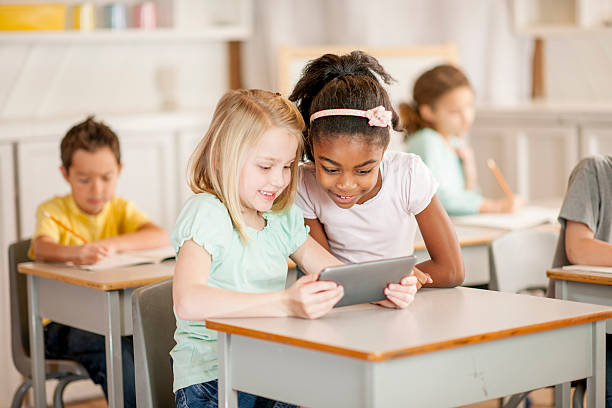 istock Girls Looking at Tablet in Class 487411304