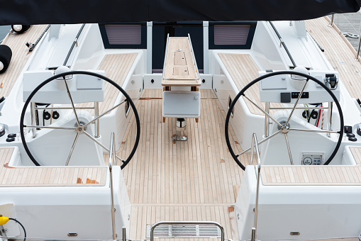 Detail of the steering wheels and symmetry in the deck of a luxury sail yatch.