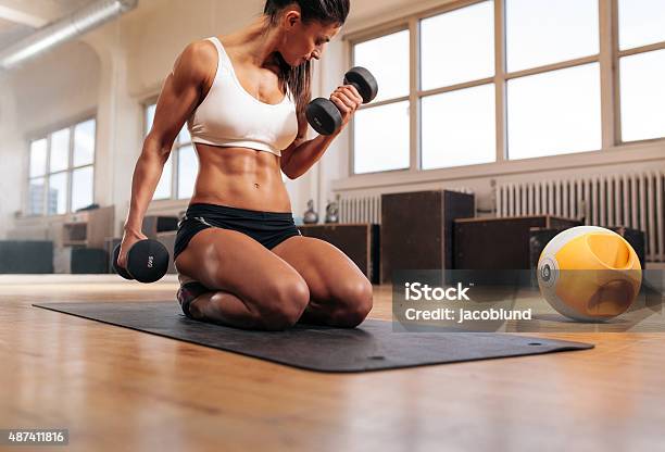 Fit Woman Working Out At The Gym With Dumbbells Stock Photo - Download Image Now - 20-29 Years, 2015, Adult