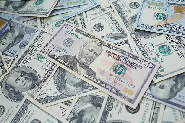istock banknotes to 100 and 50 dollars  in a chaotic manner 487417022