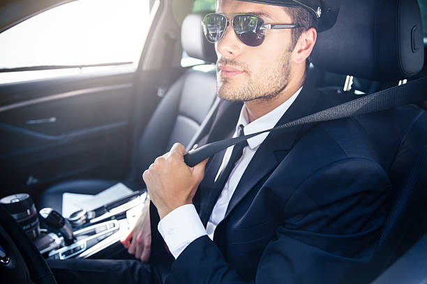 homem sentado em um carro com motorista particular - chauffeur limousine hat driver - fotografias e filmes do acervo