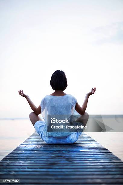 Woman Making Yoga In Front Of The Sea Stock Photo - Download Image Now - Lake, Meditating, Breathing Exercise