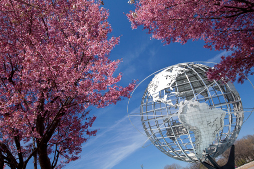 New York City, USA - April 20, 2014: The Unisphere with cherry blossom trees in Flushing Meadows Corona Park at New York City.