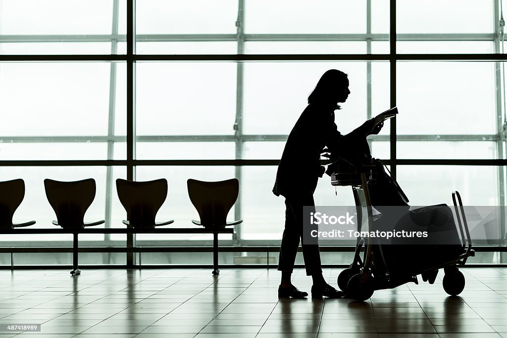 Silhueta de mulher traveller no aeroporto - Foto de stock de A caminho royalty-free