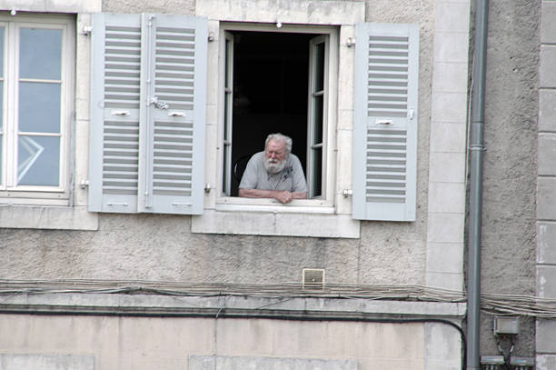 Pau, France - August 18, 2015: Typical city scene in France. Senior men looking out of the window