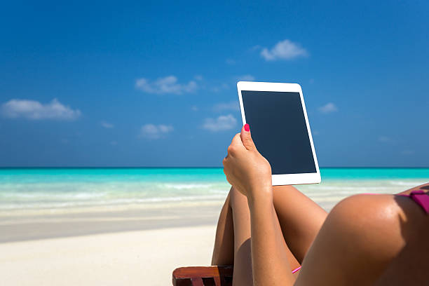 istock Blank empty tablet in hands of women on beach 487422994
