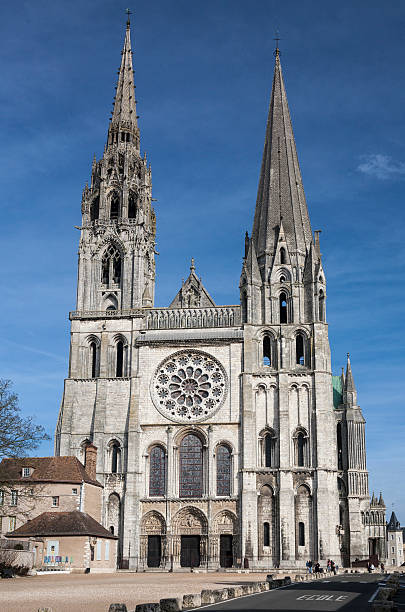 Facade of Chartres Cathedral Chartres, France - February 20, 2007: Sunshine illuminates the west front of the high gothic cathedral with its towers and rose window. Visitors visible at lower right. chartres cathedral stock pictures, royalty-free photos & images