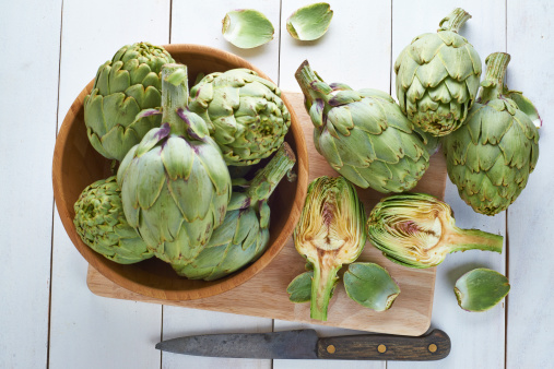 Close-up on a stack of artichokes on a market stall.
