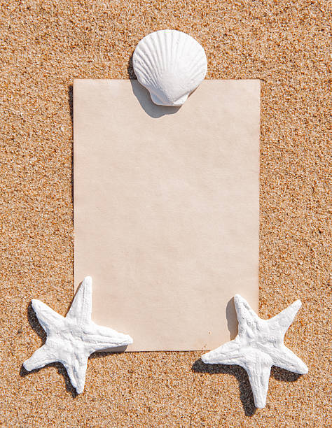istock Sheet of paper and seashells on the sand 487423631