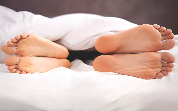 カップルのベッドの上の問題 - bed couple human foot heterosexual couple ストックフォトと画像