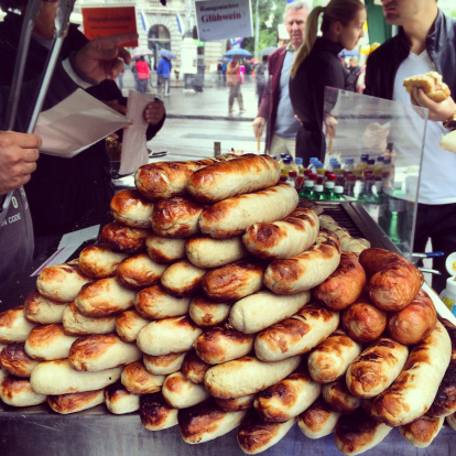 Zurich, Switzerland - April 27, 2014: People buying hot dogs on Zurich street. Pile of giant sausages ready go sale. 