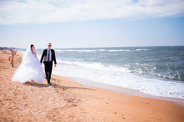 istock Young bride and groom, walking outdoors in Sunny weather 487426112