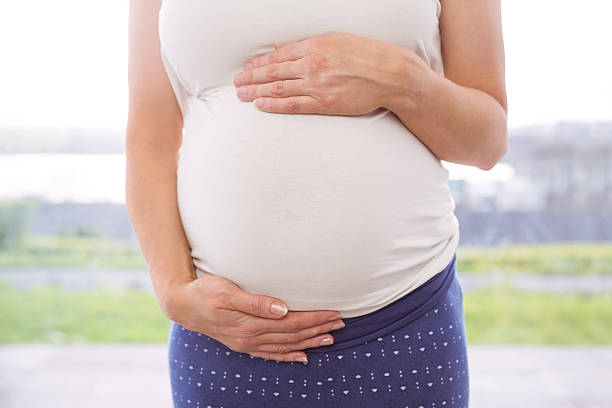istock Pregnant woman holding her bump 487426164