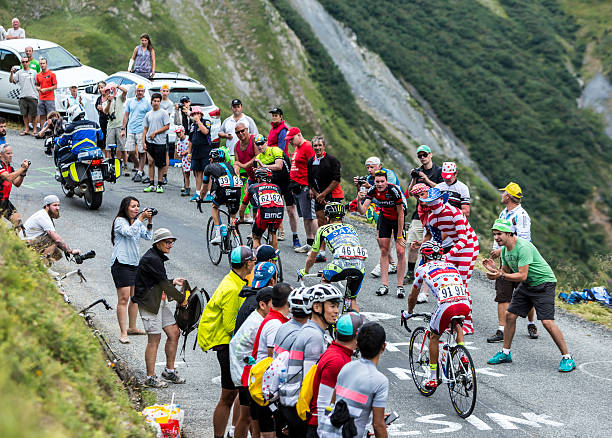Group of Four Cyclists - Tour de France 2015 Col du Glandon, France - July 24, 2015: Group of four cyclists including Polka Dot Jersey,Joaquim Rodriguez of Katusha Team,climbing the road to Col du Glandon in Alps, during the stage 19 of Le Tour de France 2015. cycling vest photos stock pictures, royalty-free photos & images