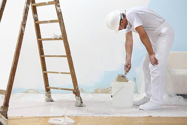 istock painter man at work takes the color with paint brush 487431044