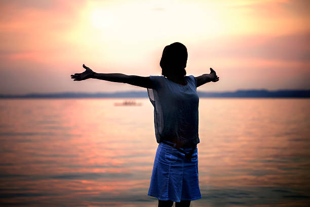 istock backlight woman taking a deep breath at the sunset 487431378