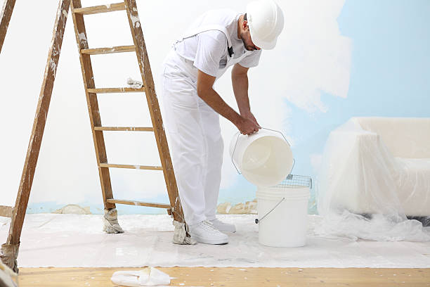 istock painter man at work pour into the bucket color 487432528