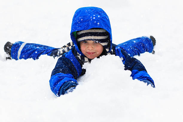 istock Little boy having fun in winter snow 487433066