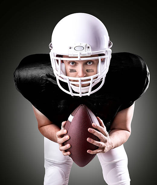 istock Football Player on black uniform on black background 487436220