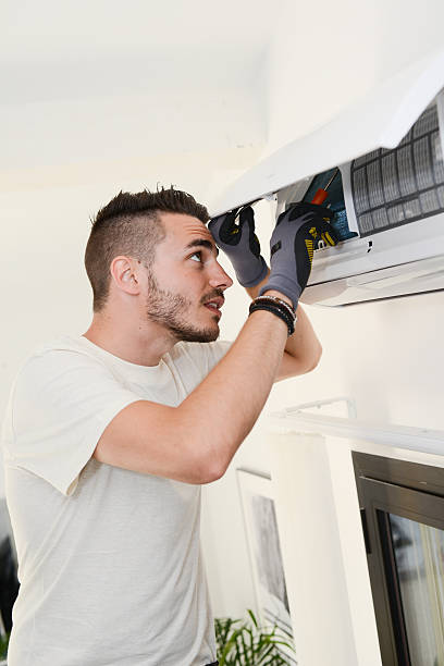 istock handsome young man electrician installing air conditioning in client house 487436252