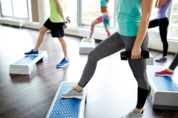 istock group of people with dumbbells and steppers 487436408