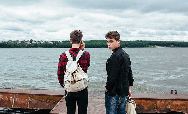 istock two young guys stand on the pier 487437454