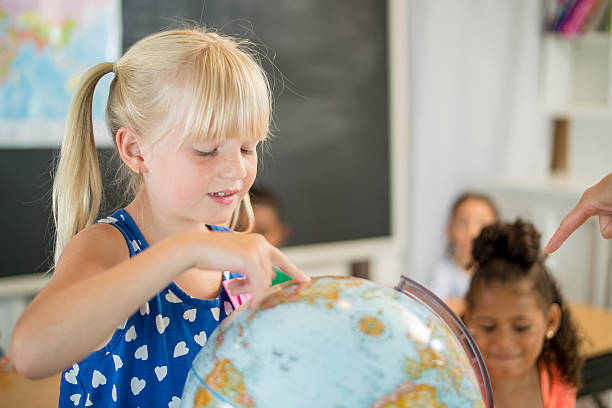 istock Little Girl Pointing at a Globe 487437480