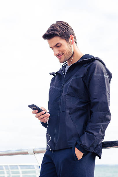 istock Man using smartphone with headphones outdoors 487441342