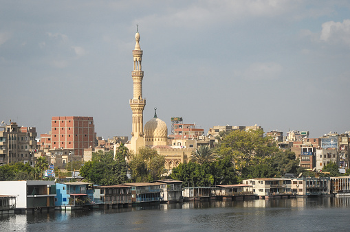 Cairo, Egypt - November 19, 2011: Riverbank in Cairo, Egypt, with mosque, residential houses and other city buildings in the background. 