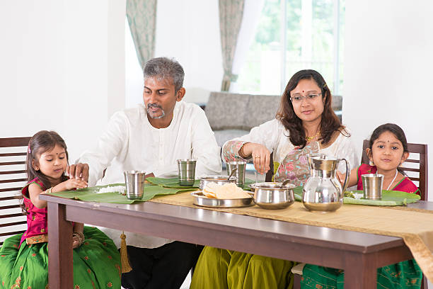 Indian family dining in kitchen Indian family dining at home. Photo of Asian people eating rice with hands. India culture. indian dinner stock pictures, royalty-free photos & images