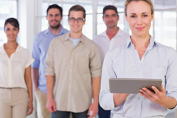 istock Businesswoman holding digital tablet with team in office 487441987