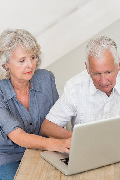 istock Concentrated senior couple using laptop together 487442077