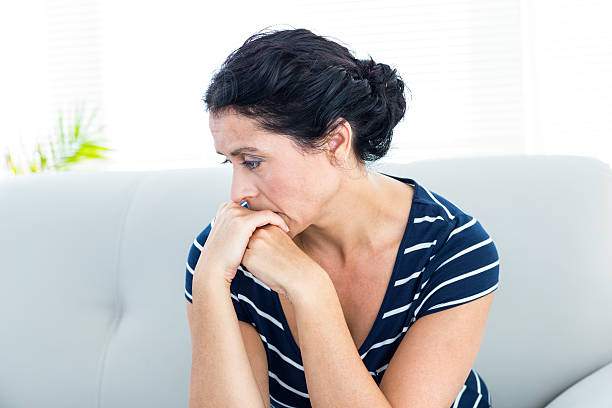 istock Unhappy woman sitting on the couch 487442632