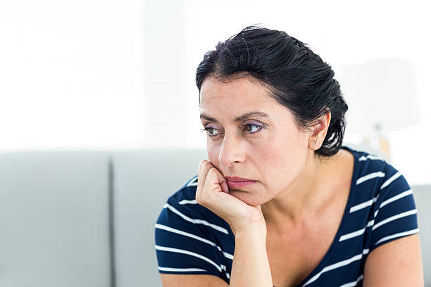 istock Unhappy woman sitting on the couch 487442644