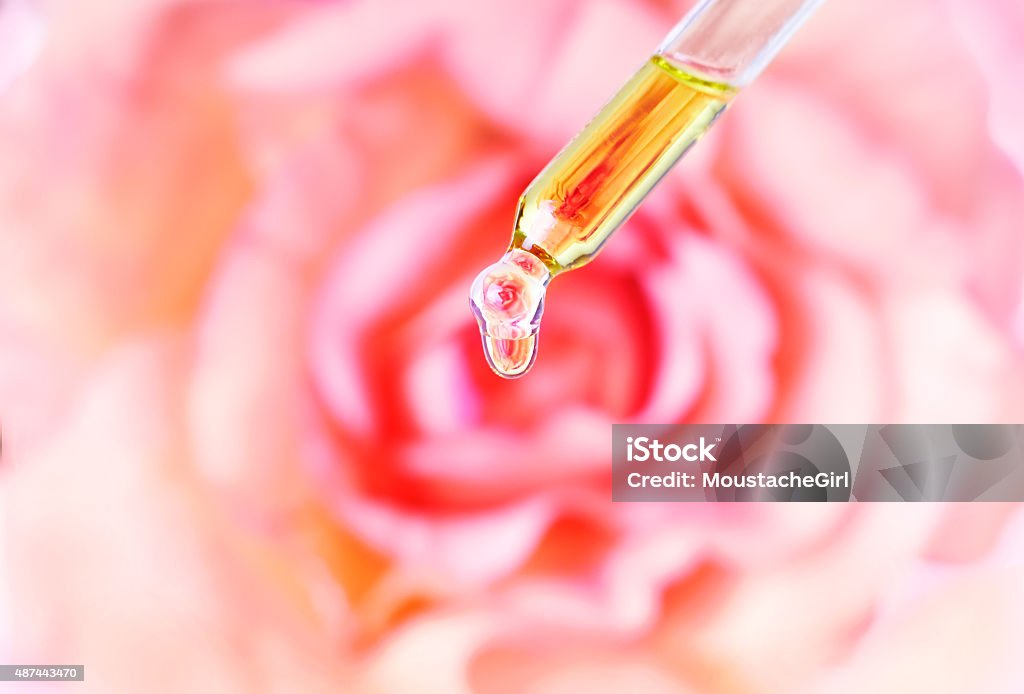 Óleos essenciais de rosa água caindo do Pipeta para garrafa. TM - Foto de stock de Rosa - Flor royalty-free