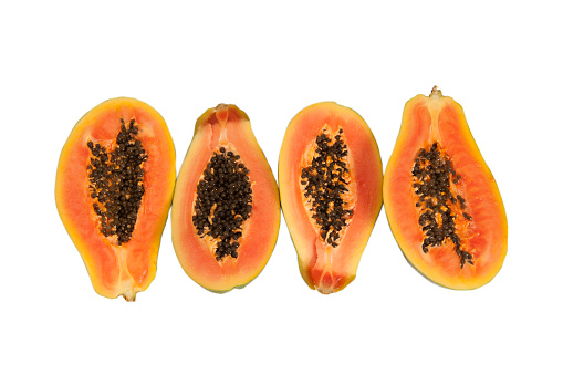 Whole and half sliced papaya fruit isolated on white background. Top view. Flat lay.