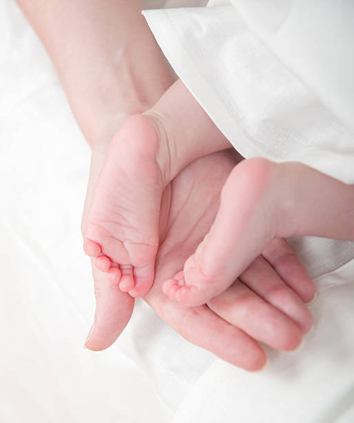 istock Mama`s hand and baby`s feet 487444057