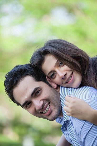 istock Man giving woman piggy back having fun 487444742