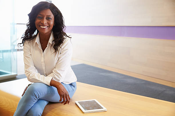 istock Young mixed race woman sitting cross legged, to camera 487445194