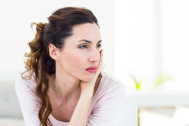 istock Sad brunette sitting on the couch 487448514