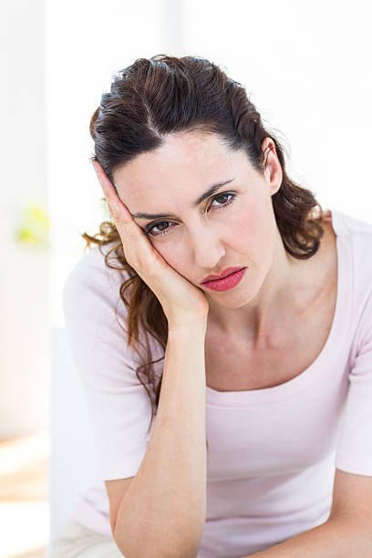 istock Upset brunette sitting on the couch 487449080
