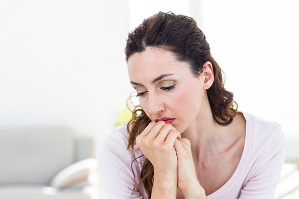 istock Sad brunette sitting on the couch 487449084