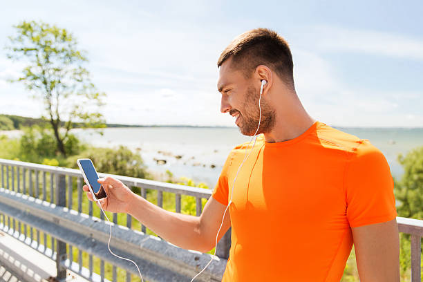 istock smiling young man with smartphone and earphones 487450342