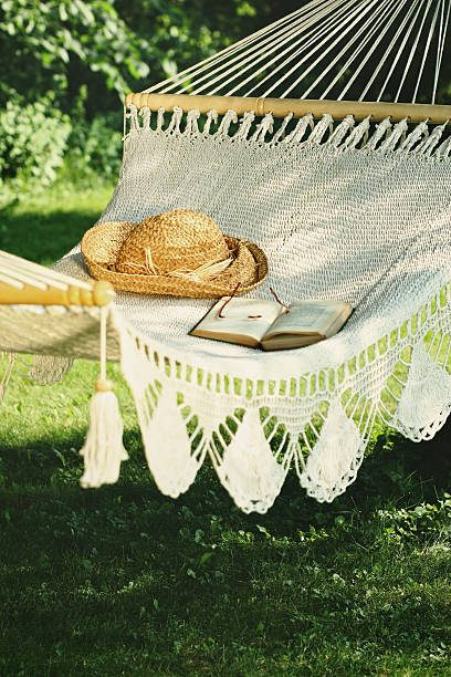 Crocheted hammock with straw hat and book stock photo