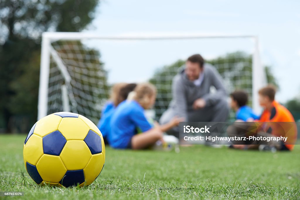 Trainer und Team über Taktik mit Fußball Ball In Foregroun - Lizenzfrei Fußball Stock-Foto