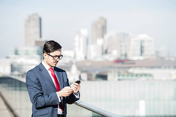 istock Businessman using smart phone above city 487452834