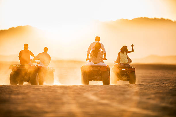 istock Back view of group of people driving quad bikes. 487456066