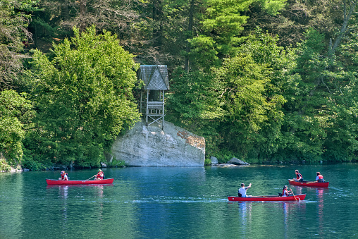 New Paltz, NY, USA - July 11, 2015:  Guests of Mohonk Mountain House enjoy canoeing on Mohonk Lake.  The lake is half a mile long and 60 feet deep, and guests ice skate on it during winter months.