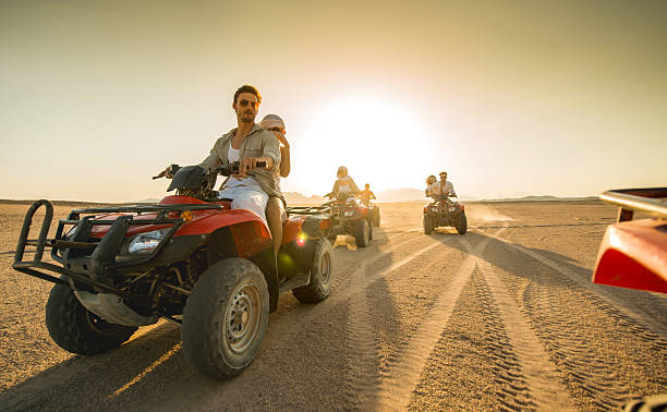 istock Group of friends having fun on quad bikes at sunset. 487458538